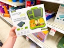 hand holding a bentgo box in front of a target shelf