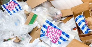 dumpster with bath and body works bags, boxes, and packaging filler
