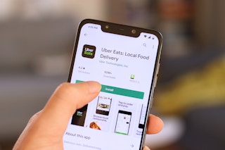 A person downloading the Uber Eats app onto their cell phone.