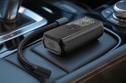 Anycash Tire Inflator Portable Air Compressor sitting on a vehicle center console.