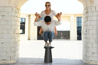 Lifestyle image of the Suproot Telescopic Stool of 2 people balancing on top