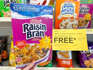 hand holding up box of Raisin Bran in front of a BOGO Free sign at Walgreens