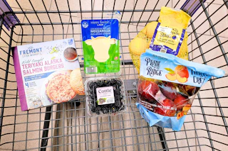 salmon burgers, blackberries, sliced cheese, peaches, and lemons in a cart