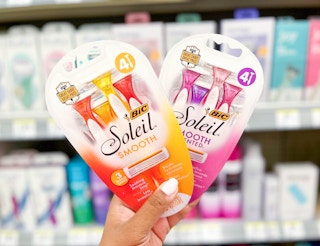 hand holding two packs of BIC Soleil Razors in aisle
