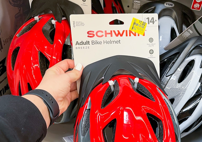 person holding walmart schwinn bike helmet with $1 clearance tag