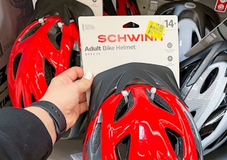 person holding walmart schwinn bike helmet with $1 clearance tag