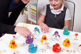 a child playing with rubber ducks