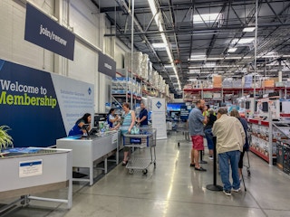 Customers standing in line, waiting to be helped at Sam's Club Customer service and returns counter.