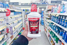 hand holding a bottle of colgate mouthwash