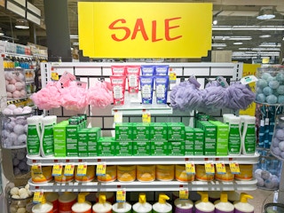 A shelf of body care items in Whole Foods with large SALE signs
