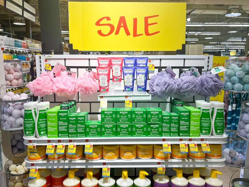 A shelf of body care items in Whole Foods with large SALE signs