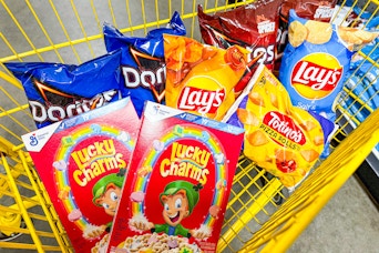 2 boxes of lucky charms, 6 bags of chips and a bag of pizza rolls in a cart