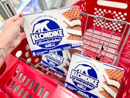 hand holding box of Klondike ice cream in front of shopping cart