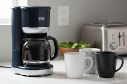 dash coffee maker with coffee cups around it