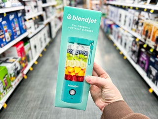 person holding a blendjet personal blender in a store