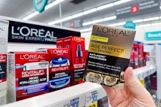 person holding a loreal moisturizer in front of the loreal display