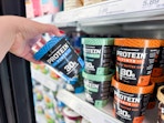 hand grabbing a protein pints ice cream off a target shelf