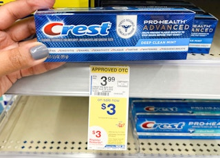 hand holding box of Crest toothpaste next to sales tag