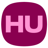 A white cloth-backed, 4-legged chair in a room with a red wall