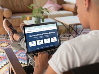 person on laptop browsing military and veteran benefits online
