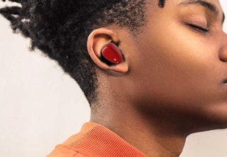 a person wearing red bluetooth earbud headphones