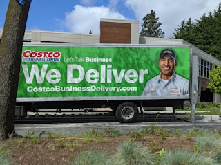 A Costco Business Center delivery truck parked outside its destination
