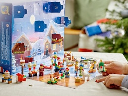 hands holding Christmas Lego figures on a table from an advent  calendar