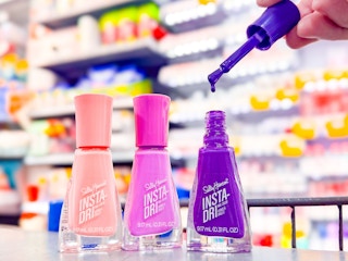 3 Sally Hansen Nail Polishes with one opened to show the nail polish color (purple)