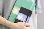 person holding notebooks