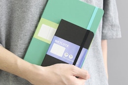 person holding notebooks
