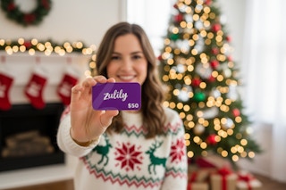 a woman holding a zulily gift card