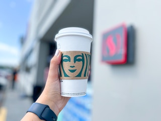 holding up Starbucks cup outside of Safeway