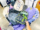 hand holding a backpack in clearance bin at kroger