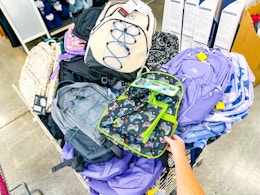hand holding a backpack in clearance bin at kroger