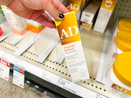 hand holding a a+d healing ointment in front of a target shelf