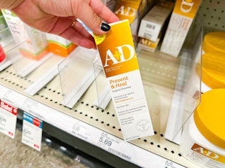 hand holding a a+d healing ointment in front of a target shelf