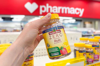 person holding a bottle of nature made multivitamins