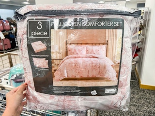 someone touching a 3-piece comforter set