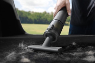 Person using the HOTO Handheld Car Vacuum Cleaner.