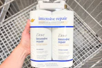 hand holding dove hair care set over shopping cart