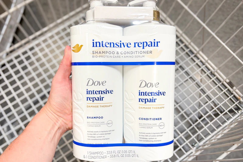 hand holding dove hair care set over shopping cart