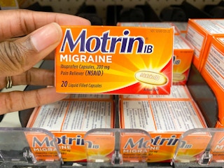 hand holding up box of Motrin in store medicine aisle
