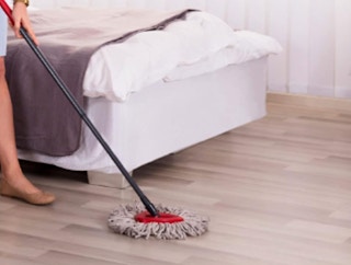 a person mopping hard wood floors with a mop