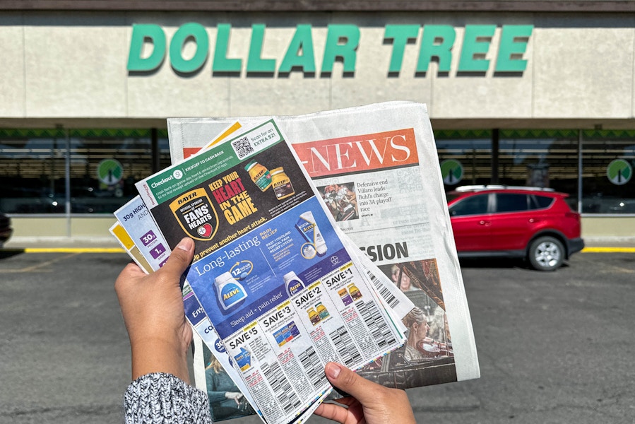 a person holding a newspaper outside dollar tree