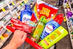 person pushing a cart with colgate, purex, garnier, lucky charms, and persil in it