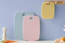 three colorful cutting boards against a wall