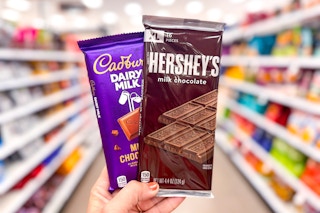 hand holding 2 candy bars in a target aisle