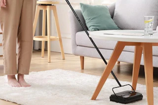 a carpet sweeper being used on a rug