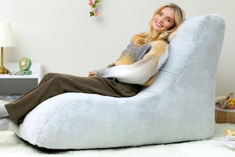A young woman sits in a memory foam accent chair
