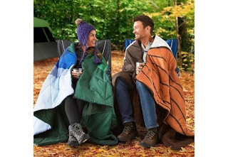 people wrapped in camping blankets